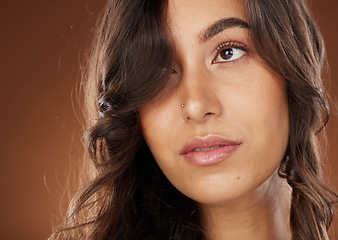 Image showing Hair, beauty and skincare with a model woman in studio on a brown background for natural or keratin treatment. Face, haircare and salon with an attractive young female posing to promote a product