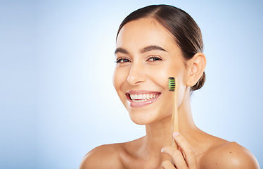 Image showing Face portrait, dental and woman with toothbrush in studio isolated on a blue background. Oral wellness, veneers and happy female model holding product for brushing teeth, cleaning and oral hygiene.
