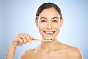 Image showing Face portrait, dental and woman with toothbrush in studio isolated on a blue background. Oral wellness, veneers and happy female model holding product for brushing teeth, cleaning and oral hygiene.