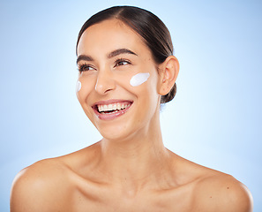 Image showing Face, beauty skincare and woman with cream in studio isolated on a blue background. Thinking, cosmetics and female model apply facial lotion, creme and moisturizer product for healthy skin hydration.