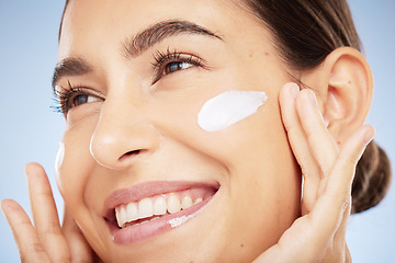 Image showing Woman, face or skincare cream on blue background in studio healthcare wellness, dermatology self love or Portugal hydration treatment. Zoom, smile or happy beauty model with sunscreen facial product