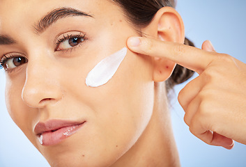 Image showing Portrait, skincare and moisturizer with a model woman in studio on a gray background for antiaging beauty. Face, lotion and product with an attractive young female inside to apply facial treatment