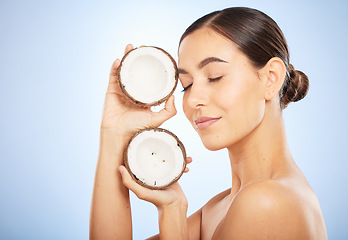 Image showing Skincare, wellness and face of woman with coconut on blue background for dermatology, body care and beauty. Spa, salon and girl with fruit for natural beauty products, cosmetics and facial treatment