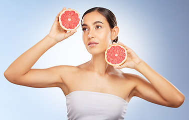 Image showing Woman, beauty and natural skincare with grapefruit, radiant glow and healthy aesthetic by blue background. Model, skin shine and fruit for wellness, self care and cosmetic health by studio background