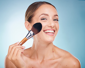 Image showing Face portrait, skincare and woman with makeup brush in studio isolated on a blue background. Product, cosmetics tool and aesthetics of happy female model with accessory to apply foundation for beauty