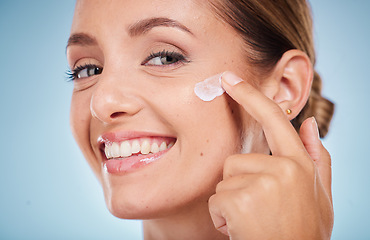 Image showing Skincare, beauty and portrait of a woman with face cream for health, wellness and natural face routine. Cosmetic, happy and model with facial lotion, spf or creme isolated by a blue studio background