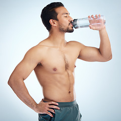 Image showing Fitness, health or man drinking water in studio after training in workout or exercise for body goals or wellness. Motivation, weight loss or tired healthy person relaxing and drinks liquid or bottle