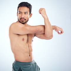 Image showing Health, fitness and man stretching arm for flexibility in studio isolated on a blue background. Thinking, sports and young male athlete, warm up and getting ready for training, exercise and workout.