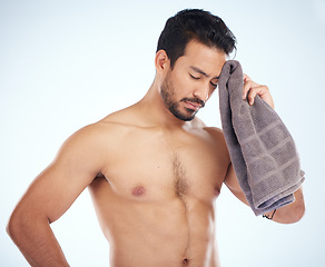 Image showing Man with towel after fitness, tired and sweat from workout with health and body care against studio background. Sports training, motivation and exhausted athlete wipe head with wellness and cardio.