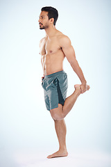 Image showing Fitness, health and man stretching leg in studio isolated on a blue background mock up. Sports, body wellness and young male athlete stretch, warm up and preparing for workout, exercise and training.