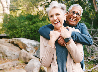 Image showing Hiking, laugh and romance with a senior couple hugging while in the woods or nature forest together in summer for a hike. Fun, joke and bonding with a mature man and woman enjoying retirement outdoor