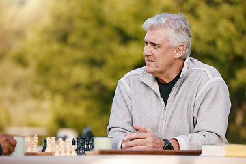 Image showing Senior man, park and thinking for chess, game and competition at table by trees, sunshine and focus. Elderly chess player, outdoor and strategy for contest in nature, relax and play in Los Angeles