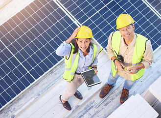 Image showing Solar panels, digital tablet and top view of team doing maintenance, repairs or inspection. Solar energy, collaboration and portrait of industry workers on rooftop of building for photovoltaic cells.