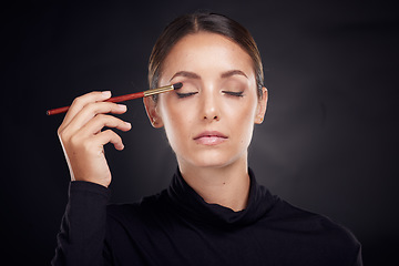 Image showing Makeup, brush or model with beauty luxury products or cosmetics for self care in studio on black background. Skincare, relax or young woman brushes foundation powder or eyeliner in facial treatment