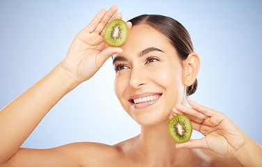 Image showing Beauty, kiwi and woman with face and smile, skincare and organic, vegan cosmetic care for healthy skin. Microblading, natural cosmetics and hands frame with fruit, facial and glow on blue background.