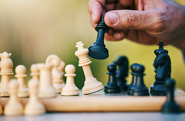 Image showing Chess, play or hand with a king on a board game with a winning strategy in a tournament outdoors in nature. Checkmate, mindset or smart man playing in a sports contest or problem solving challenge