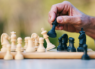 Image showing Chess, play or hand with a king on a board game with a winning strategy in a tournament outdoors in nature. Checkmate, mindset or smart man playing in a sports contest or problem solving challenge