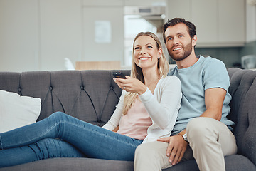Image showing Couple, home and watch television, happy on sofa with streaming movie or tv show, smile with remote control. Commitment, bond and love with routine, spending quality time in living room watching tv.