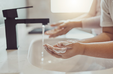 Image showing Bathroom, water and child cleaning hands with soap, foam or learning healthy hygiene together. Washing dirt, germs or bacteria on fingers, kid in home in morning for wellness, safety or skin care.