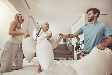 Image showing Fun, happy and a family with a pillow fight in a bedroom for bonding, playful and energy in morning. Smile, excited and a young kid playing with mother and father on a bed with a game together