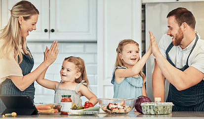 Image showing Happy family in kitchen, cooking with kids and high five with success, learning and nutrition with parents. Mom, dad and girl children making healthy food in home with care, celebration and lunch.