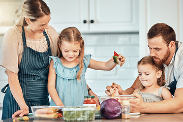 Image showing Family in kitchen, cooking together with children and teaching, learning and nutrition with parents. Mom, dad and girl kids help making healthy food in home with care, support and love at happy lunch