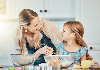 Image showing Happy woman in kitchen, baking together with child and teaching, learning and nutrition with mother. Smile, mom and girl kid helping make cookies in home with care, support and love at breakfast.
