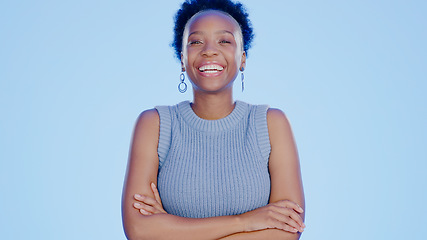 Image showing Smile, crossed arms and portrait of black woman in a studio with positive, confident and good attitude. Happy, pride and young African female model with joy and happiness isolated by blue background.