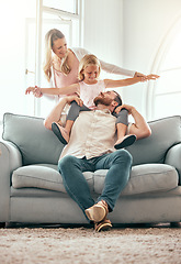 Image showing Parents, kid and airplane on sofa, smile and playful for love, care or bonding in living room at family home. Father, mother and daughter with plane game, excited or together on lounge couch in house