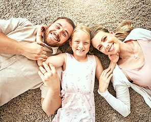 Image showing Happy, portrait and kid with parents in the living room bonding and relaxing together at home. Happiness, love and girl child laying with mother and father from Australia on floor in lounge at house.