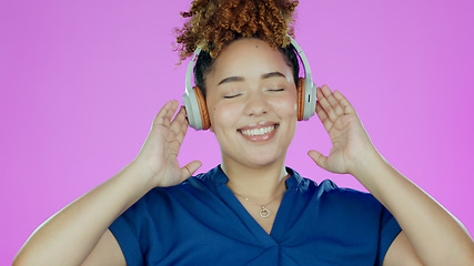 Image showing Headphones, happy and woman with music in studio listening to song, audio and radio. Dance, happiness and face of person for streaming subscription, relax and fun on purple background for wellness