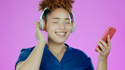 Image showing Headphones, music and woman with smartphone in studio listening to song, audio or radio. Happy, smile and face of person with mobile app for streaming subscription, relax and fun on purple background