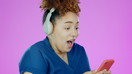 Image showing Woman, phone and wow with headphones for winner, promotion or announcement in studio on purple background. Smartphone, person and surprised for notification, sale and lottery news with mock up space