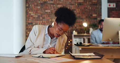 Image showing Business woman, writing notes and planning in office for startup goals, administration and schedule or reminder at night. African employee or writer in workspace with notebook, ideas or brainstorming