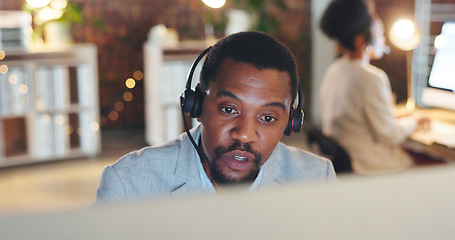 Image showing African man, call center and computer for talk, thinking or night for telemarketing, voip mic or contact us. Consultant, crm and tech support agent for customer service, idea or solution at help desk