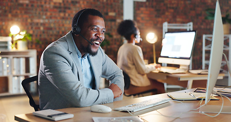 Image showing African man, call center and happy by computer, smile and excited for tech support, contact us or email. Consultant, crm or agent in night, telemarketing or customer service with smile in workplace