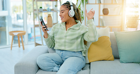 Image showing Phone, sofa and happy woman on music headphones in home living room for dancing. Mobile, radio and African person listening to podcast, audio and sound for freedom, celebration and streaming online