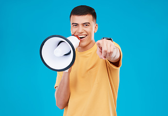 Image showing Bullhorn, happy and portrait of man in studio pointing for announcement, speech or rally. Smile, protest and young person from Canada with megaphone for loud communication isolated by blue background
