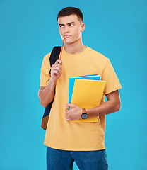 Image showing Man, student thinking and choice for college, university or scholarship with books, research and funding solution in studio. Person with decision, confused or ideas for education on a blue background
