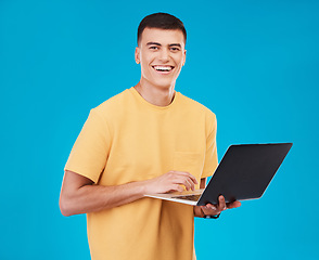 Image showing Portrait, happy man or student with laptop in studio on blue background with mockup for e learning. Male model, person and smile with technology, typing or respond to email by online and work on web