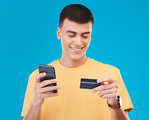 Image showing Credit card, finance and man with a smartphone, payment and economy with digital app on a blue background. Person, guy or model with a cellphone, budget and online banking with transaction or savings