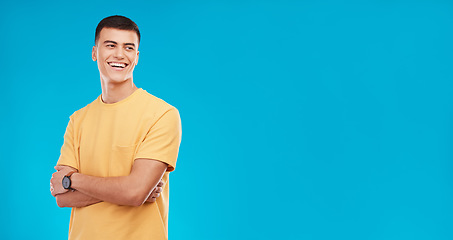 Image showing Smile, crossed arms and man in a studio with mockup space for advertising, promotion or marketing. Happy, confidence and young male model from Canada with mock up isolated by blue background.