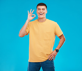 Image showing Pefect sign, happy and portrait of a man on a blue background for a review, feedback or emoji icon. Happy, agreement and a person with a gesture in studio for success, opinion or ok approval