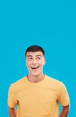 Image showing Man, face and customer with wow, surprised or open mouth expression in studio on blue background for sale. Fashion, emoji and person or guy on mock up space for deal or discount announcement or news