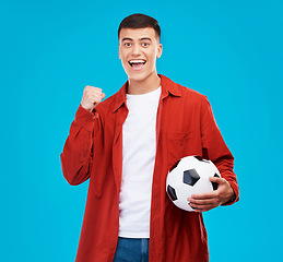 Image showing Soccer ball, excited and portrait of man on blue background for sports, winner and achievement. Happy, football fan and person cheer for team success, winning match, game and tournament in studio