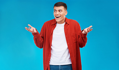 Image showing Confused, shrug and young man in a studio with options, decision or comparison expression. Shock, balance and male model from Canada with doubt hand gesture isolated by blue background with mockup.