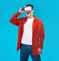 Image showing Man, wow and VR or futuristic glasses for gaming software, digital world and fantasy vision on a blue background. Excited person watch in 3d video, virtual reality technology and metaverse in studio