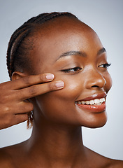 Image showing Face, skincare and fingers on the cheek of a black woman in studio on a gray background for beauty or natural wellness. Skin, spa or luxury and a young model with cosmetic or antiaging treatment