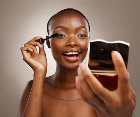 Image showing Black woman, mascara with brush and mirror, makeup and shine with beauty isolated on brown background. Eyelash extension, wand and skin glow with cosmetology, transformation and wellness in studio