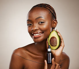 Image showing Black woman, portrait and avocado oil with product, natural beauty and skincare with vegan cosmetics on brown background. Smile for dermatology, bottle with vegetable for liquid or serum in studio